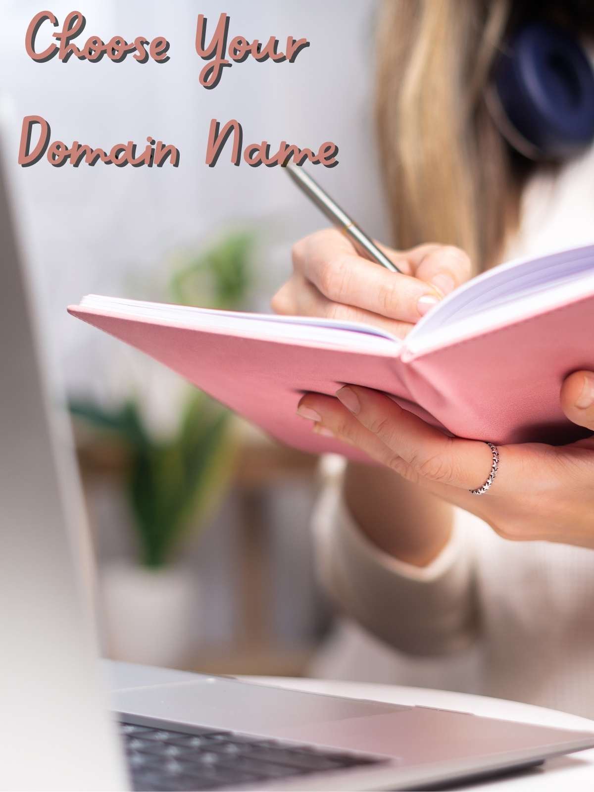 Choose your domain name. Photo of someone writing in journal, in front of computer.